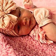 Mia joined the competition — help win amazing prizes! baby, infant, headband, pink, blanket, soft_texture, clothing, portrait, face, cute, sleepwear, newborn, toddler, lying_down, closeup, indoors, child, person, cozy, resting