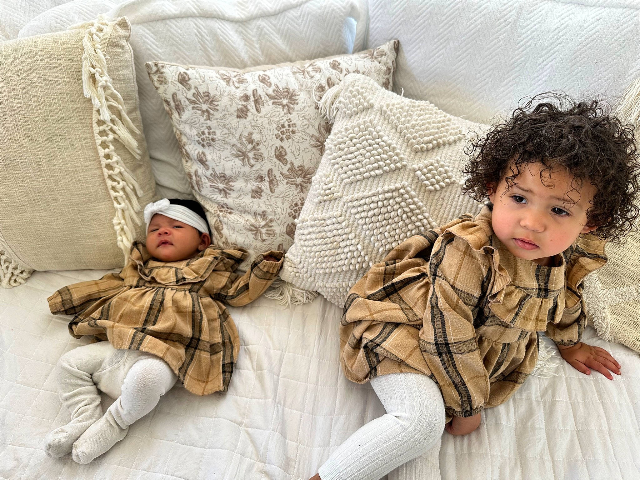 Maliyah is registered to the contest to win money with this photo: bedding, child, comfort, couch, flooring, fur, glasses, happy, head, headwear, human_leg, linens, pattern, person, plaid, sitting, sleeve, textile, thigh, throw_pillow