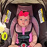 baby, child, infant, car_seat, pink_bow, pink_outfit, sitting, buckled, harness, portrait, face, blue_eyes, indoors, vehicle, safety_seat, sunlight, adorable, baby_girl, close_up, photograph