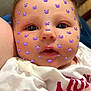baby, face, close_up, infant, filter, emoji, purple, clothing, white_shirt, red_text, skin, eyes, mouth, arm, cute, expression, indoor, portrait, child, head
