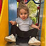 Shelly participe au concours pour gagner de l'argent avec cette photo : child, toddler, slide, playground, outdoor, sneakers, white_shirt, black_leggings, hair_bun, person, park, play_equipment, metal_slide, yellow, blue, red, nature, trees, daylight, smiling