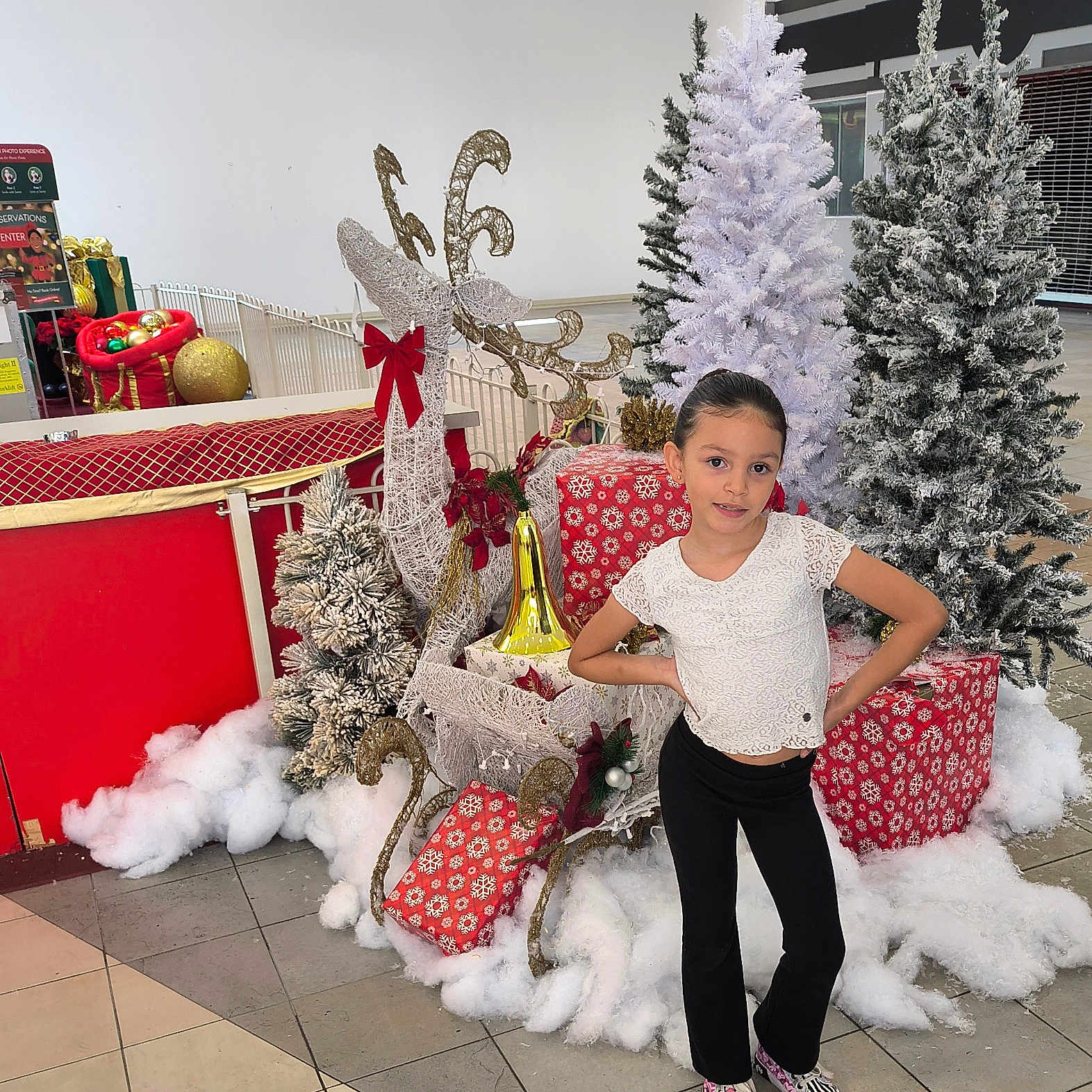 Isabella is registered to the contest to win money with this photo: accessories, bag, child, christmas, christmasdecorations, christmastree, christmastreeornaments, clothing, face, female, festival, footwear, girl, handbag, head, openingpresent, person, plant, shoe, tree