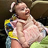 Rebecca is registered to the contest to win money with this photo: baby, child, smiling, pink_dress, bow, blanket, arm, hand, face, person, indoor, chair, seating, happy, cute, infant, holding, fabric, pattern, event