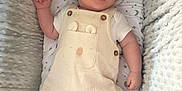 River-Bleu is registered to the contest to win money with this photo: baby, infant, child, overalls, clothing, cushion, stars, moon, plush, soft, comfort, lying_down, cute, face, smile, happy, indoor, portrait, newborn, resting