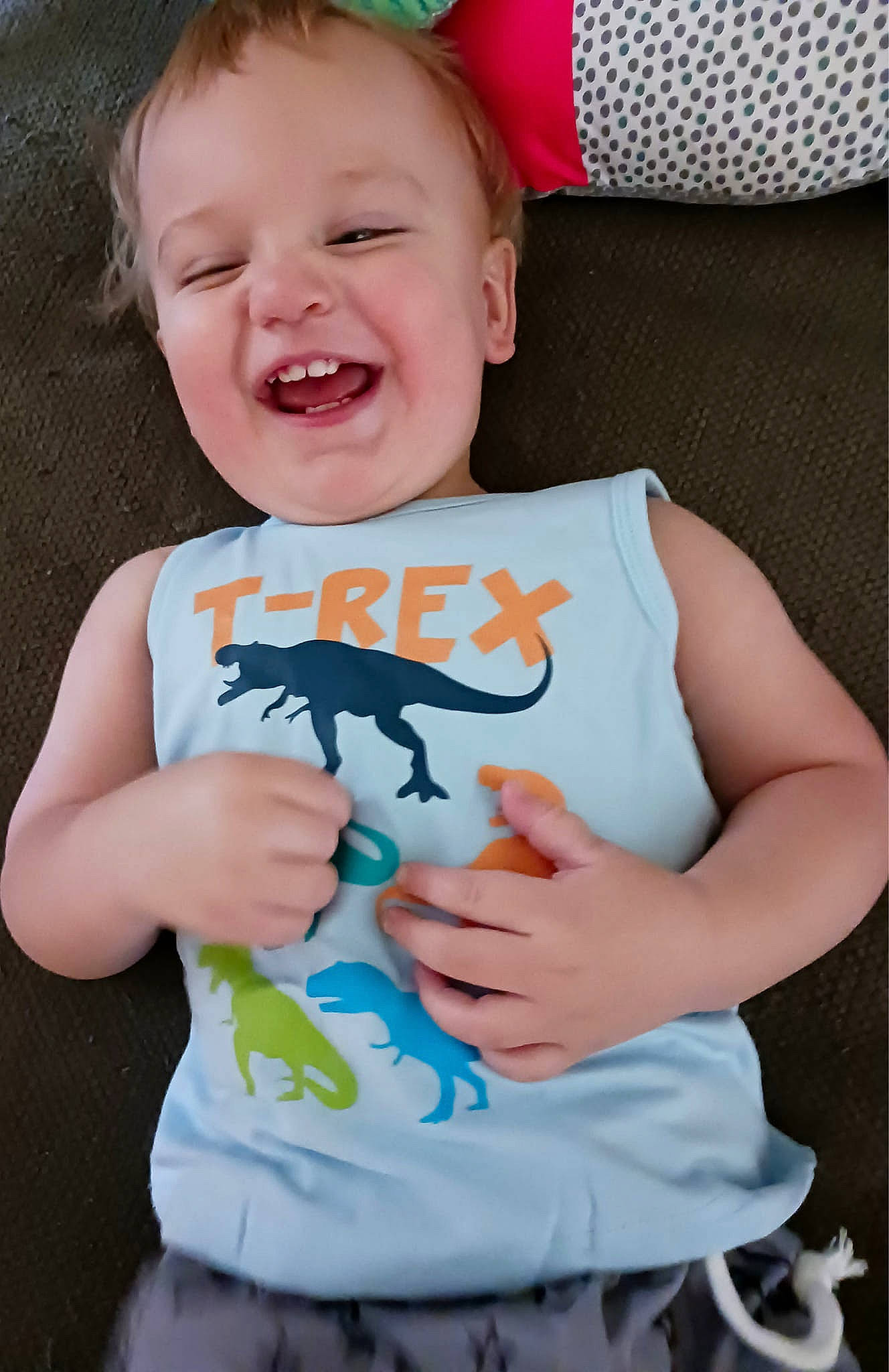 Cassius is registered to the contest to win money with this photo: arm, baby, baby_toddler_clothing, child, facial_expression, finger, font, fun, hand, happy, mouth, neck, pattern, person, pink, skin, sleeve, smile, t_shirt, toddler