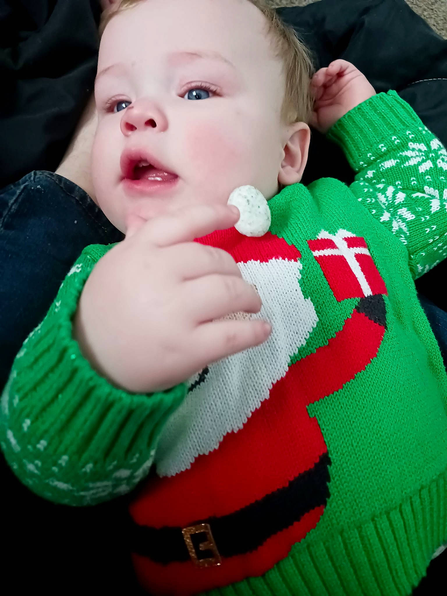 Atlas is registered to the contest to win money with this photo: baby, baby_toddler_clothing, carmine, cheek, child, christmas, christmas_decoration, christmas_eve, event, fictional_character, finger, grass, green, happy, holiday, pattern, person, sitting, sleeve, textile
