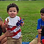 Lincoln joined the competition — help win amazing prizes! child, toddler, curly_hair, pinwheel, snack, bib, shorts, grass, blanket, outdoor, park, family, play, happy, smile, person, summer, fun, casual, picnic