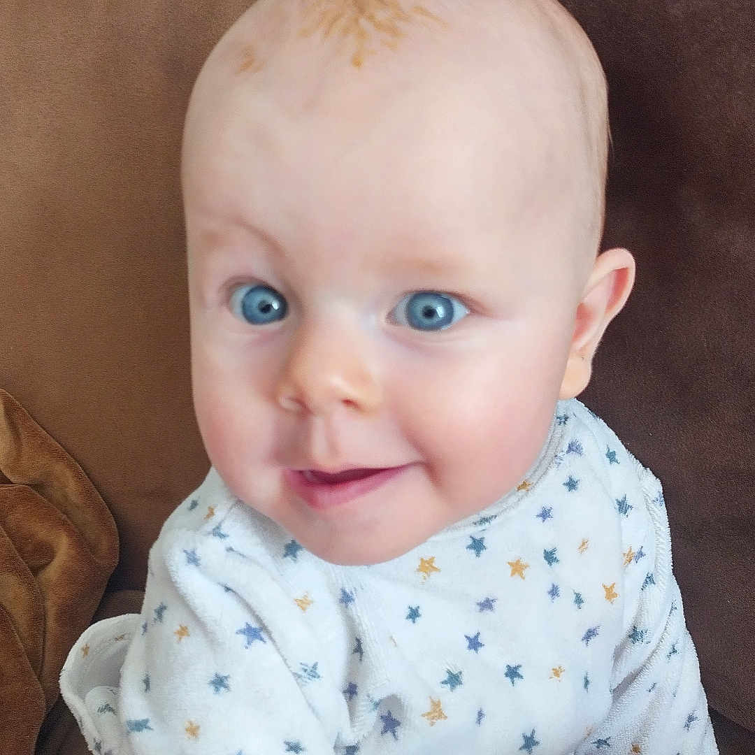 Virgil a rejoint le concours — aidez-le/la à gagner de superbes lots ! baby, blue_eyes, brown_couch, child, closeup, colorful, couch, cozy, cute, face, happy, indoor, infant, onesie, person, plush_toy, portrait, smile, soft_toy, star_pattern