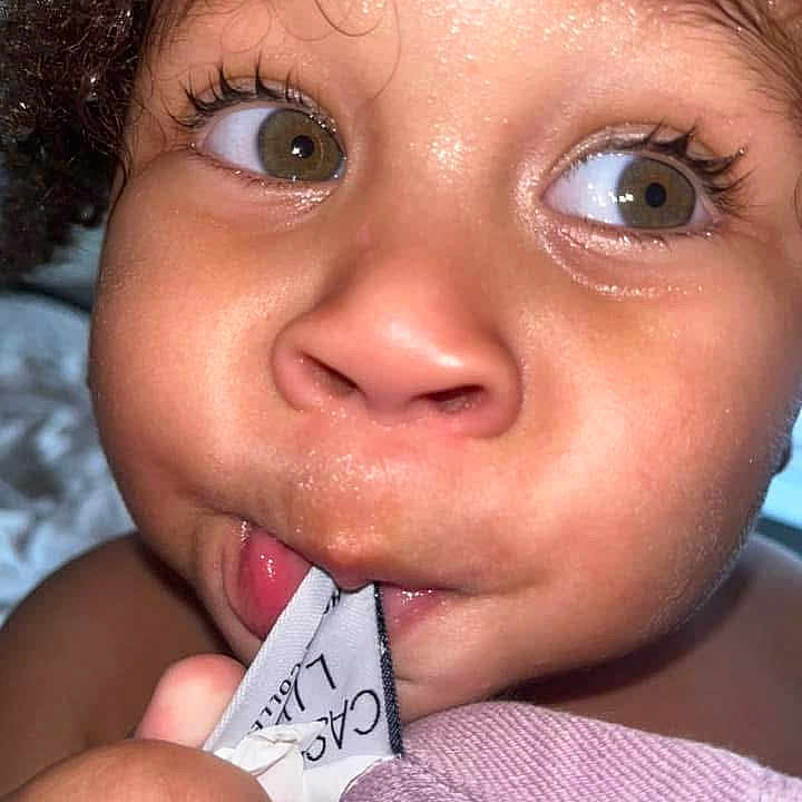 Neko Pitts joined the competition — help win amazing prizes! baby, chewing, child, close_up, curiosity, curly_hair, cute, expression, eyes, fabric, face, hand, indoors, label, playful, portrait, skin, soft_texture, toddler, young