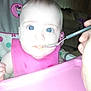 baby, feeding, high_chair, spoon, pink_bib, blue_eyes, indoor, child, person, face, hand, furniture, table, infant, closeup, cute, expression, young, skin, seat