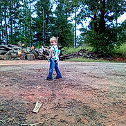 Layla joined the competition — help win amazing prizes! casual_clothing, child, daylight, dirt, environment, footwear, forest, grass, jeans, logs, nature, outdoor, person, playful, pose, smile, trees, tshirt, wood, young