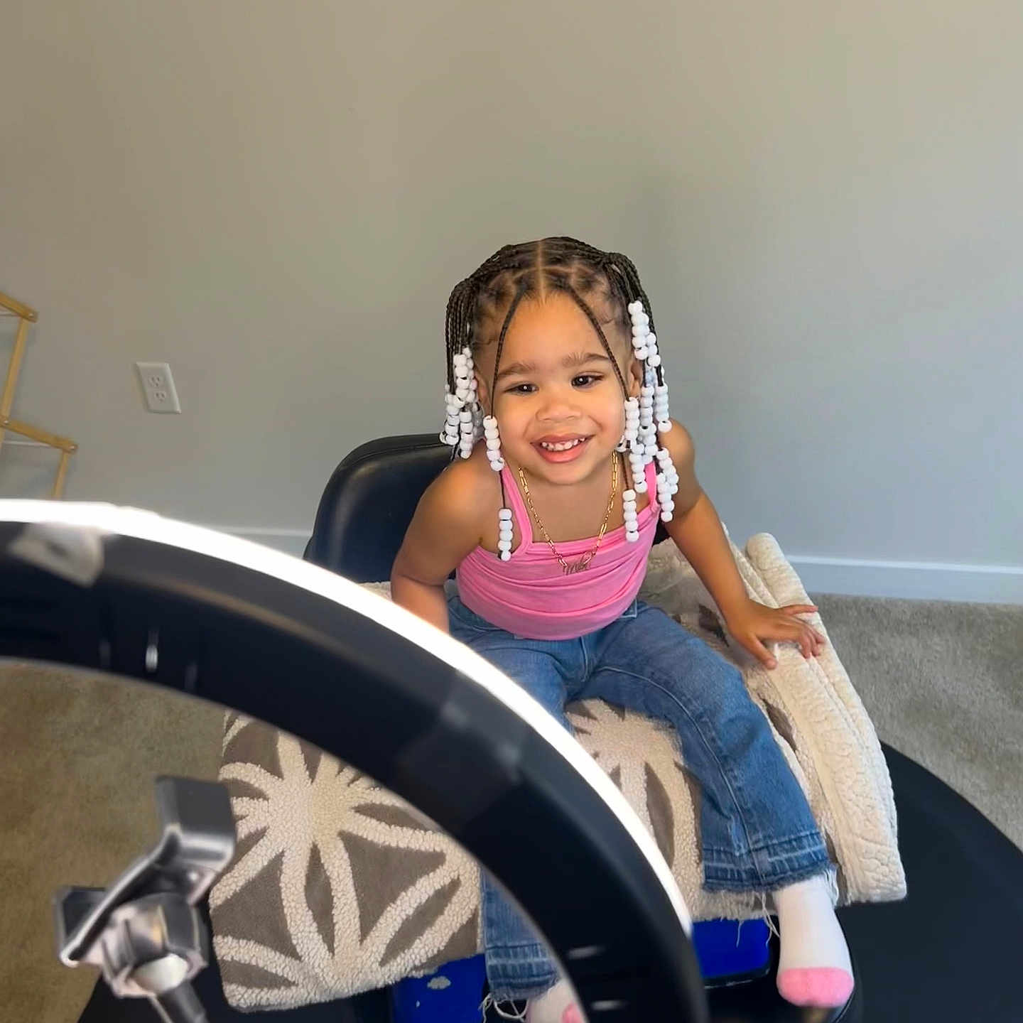 Mila is registered to the contest to win money with this photo: braid, child, clothing, face, female, furniture, girl, hair, happy, head, jeans, machine, pants, person, racket, sitting, smile, sport, tennis, wheel