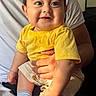 baby, child, infant, smiling, happy, portrait, indoor, sitting, yellow_shirt, shorts, socks, adult, parent, arms, closeup, face, eyes, family, home, photography