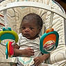 baby, baby_seat, child, clothing, colorful, cushion, cute, face, hands, human, indoor, infant, plastic_toy, playtime, seat_belt, small, striped_shirt, toy, wood_floor, young