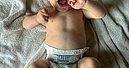 Jaxxon is registered to the contest to win money with this photo: baby, diaper, towel, smiling, infant, skin, barefoot, happy, lying_down, child, cute, small, newborn, person, young, playful, indoors, light, portrait, expression