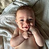 Jaxxon is registered to the contest to win money with this photo: baby, infant, smile, face, hand, skin, towel, lying_down, cute, happy, child, portrait, young, person, baby_skin, indoors, expression, human, resting, closeup