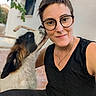 Baloo participe au concours pour gagner de l'argent avec cette photo : woman, dog, selfie, portrait, glasses, smiling, person, pet, black_and_white_dog, fluffy, animal, outdoor, house, wall, window, plants, necklace, black_clothing, sitting, photobomb