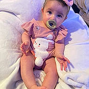 Celeste joined the competition — help win amazing prizes! baby, infant, child, pacifier, pink_outfit, headband, bunny_design, blanket, sitting, cute, soft_texture, indoors, portrait, young_child, clothing, footwear, hand, face, eyes, expression