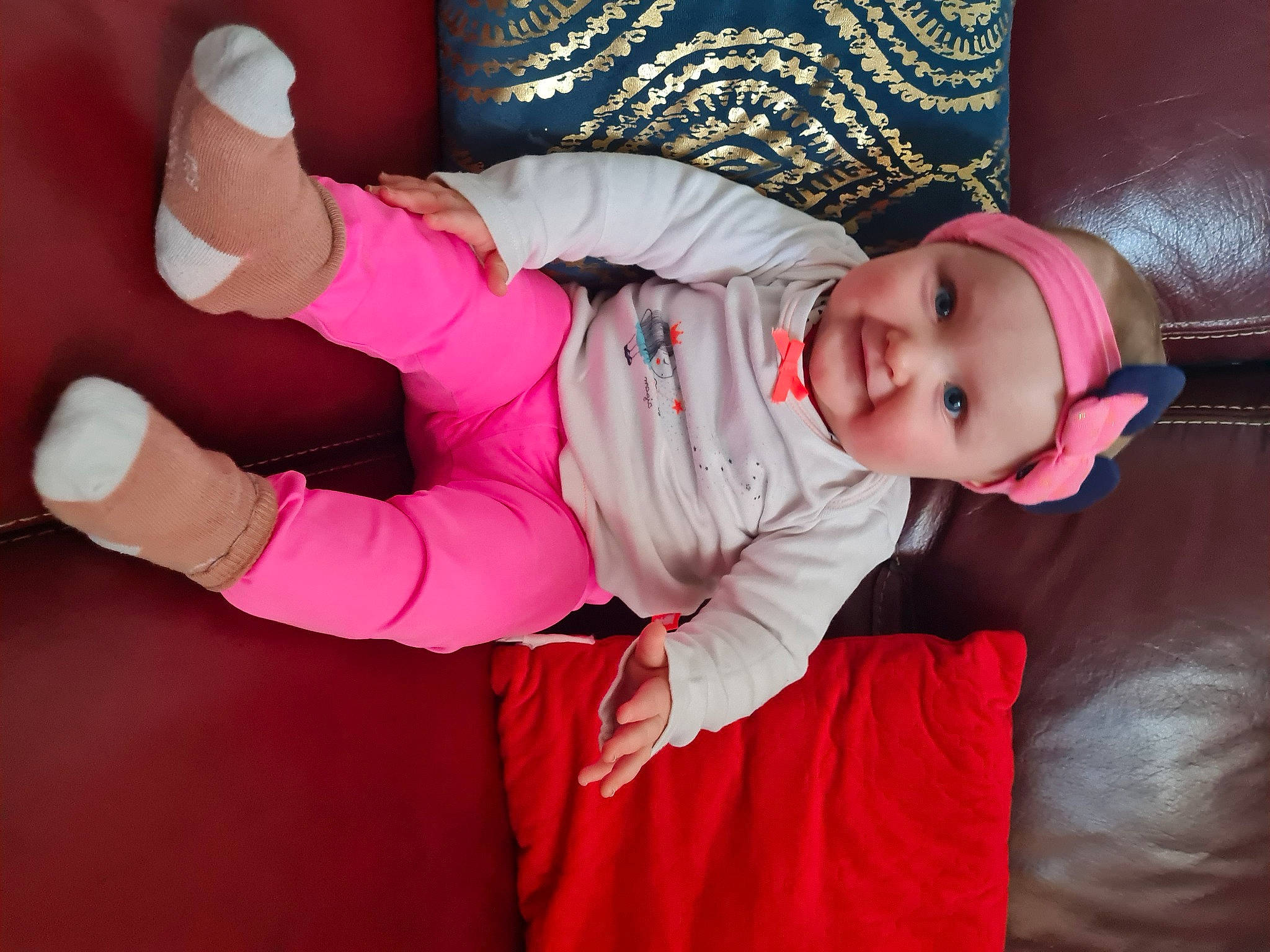 Emmy participe au concours pour gagner de l'argent avec cette photo : baby, baby_toddler_clothing, cheek, child, comfort, eye, finger, fun, gesture, headwear, human_body, lap, leg, magenta, person, pink, purple, skin, sleeve, smile