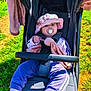 baby, blanket, child, cute, daylight, grass, hat, infant, nature, outdoor, pacifier, portrait, purple_clothing, relaxing, seatbelt, socks, stroller, sunhat, sunlight, toy