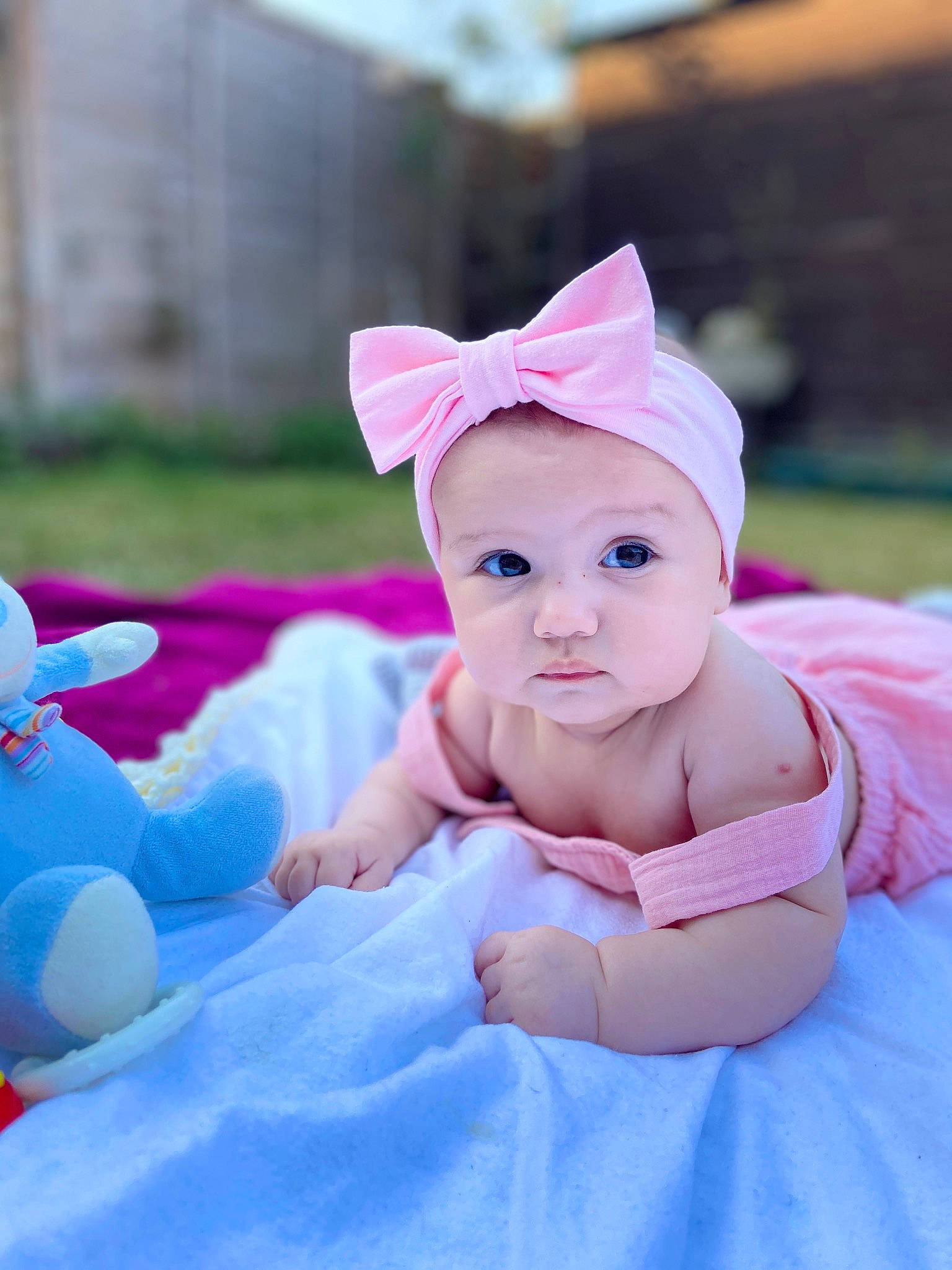 Emma is registered to the contest to win money with this photo: baby, baby_toddler_clothing, cap, child, facial_expression, fashion_accessory, fun, grass, happy, hat, headwear, leisure, magenta, person, pink, play, purple, recreation, sitting, skin