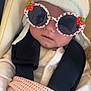 accessory, baby, blanket, car_seat, child, clothing, cute, face, fashion, hat, headwear, indoors, infant, person, pink, portrait, seatbelt, sunglasses, warm, white