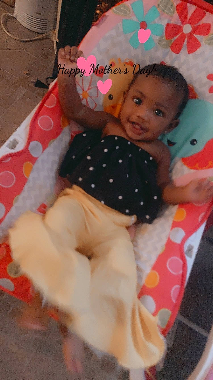 Royalty is registered to the contest to win money with this photo: arm, baby, baby_products, baby_toddler_clothing, child, eye, face, fun, hairstyle, hand, happy, head, pattern, person, pink, plaid, skin, smile, stuffed_toy, thigh