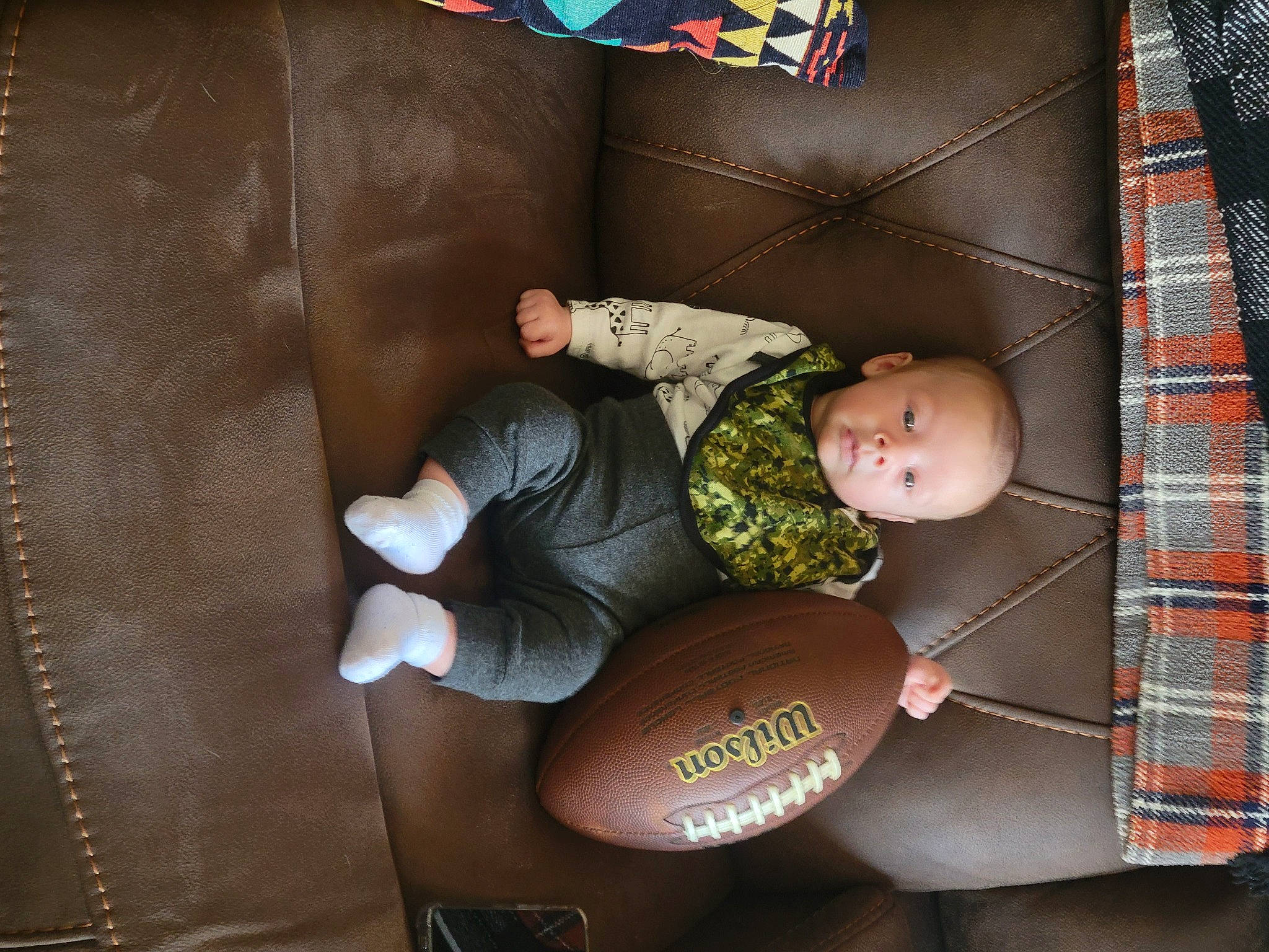 Dennis is registered to the contest to win money with this photo: baby, baby_products, baby_toys, brown, child, comfort, fashion_accessory, fun, hat, helmet, linens, orange, pattern, person, room, sitting, space, textile, toddler, toy