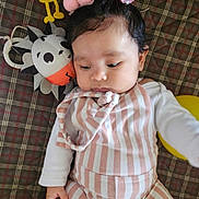 Elizabeth joined the competition — help win amazing prizes! baby, child, colorful, cozy, cute, face, hand, indoor, infant, lying_down, pink_pompoms, plaid_blanket, playtime, portrait, resting, soft_toys, striped_clothing, toy_cupcake, toy_hedgehog, white_sleeves