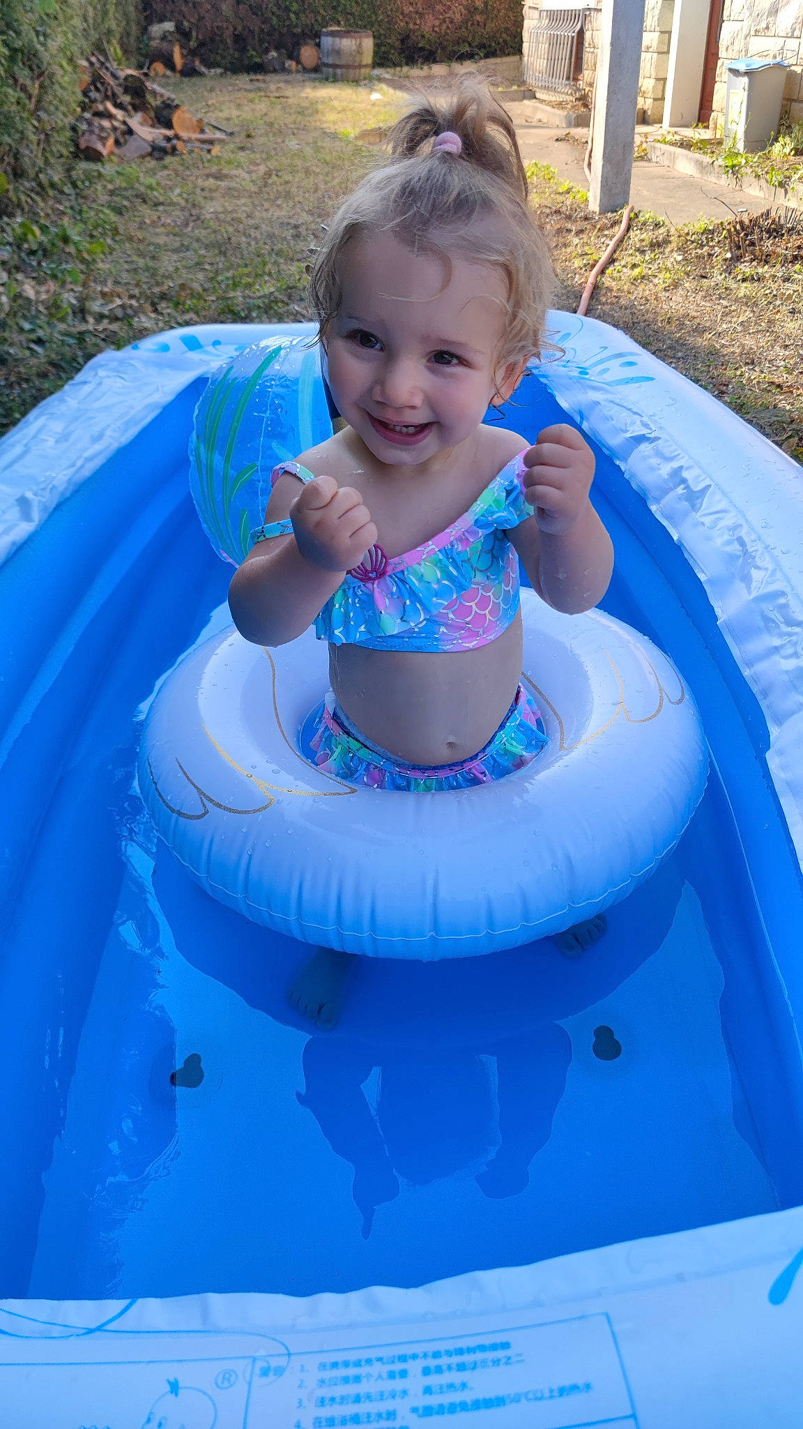 Lya a rejoint le concours — aidez-le/la à gagner de superbes lots ! baby, baby_toddler_clothing, bathing, blue, child, fun, grass, happy, inflatable, joy, leisure, nonbuilding_structure, outdoor_recreation, person, photograph, pink, recreation, smile, summer, toddler