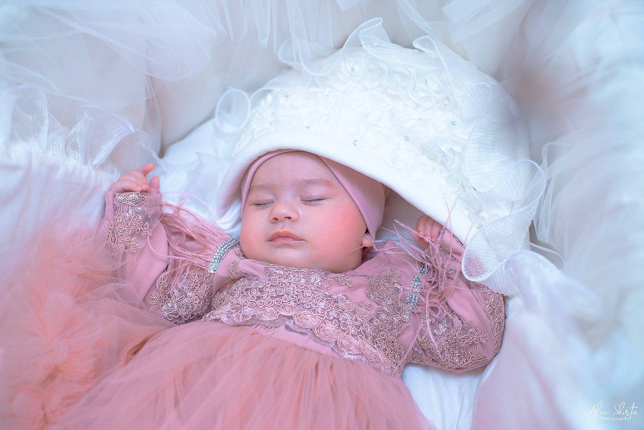 Selena is registered to the contest to win money with this photo: baby, baby_sleeping, bedding, bedtime, child, comfort, dress, event, eye, eyebrow, face, fur, happy, headgear, headwear, linens, lip, person, pink, room