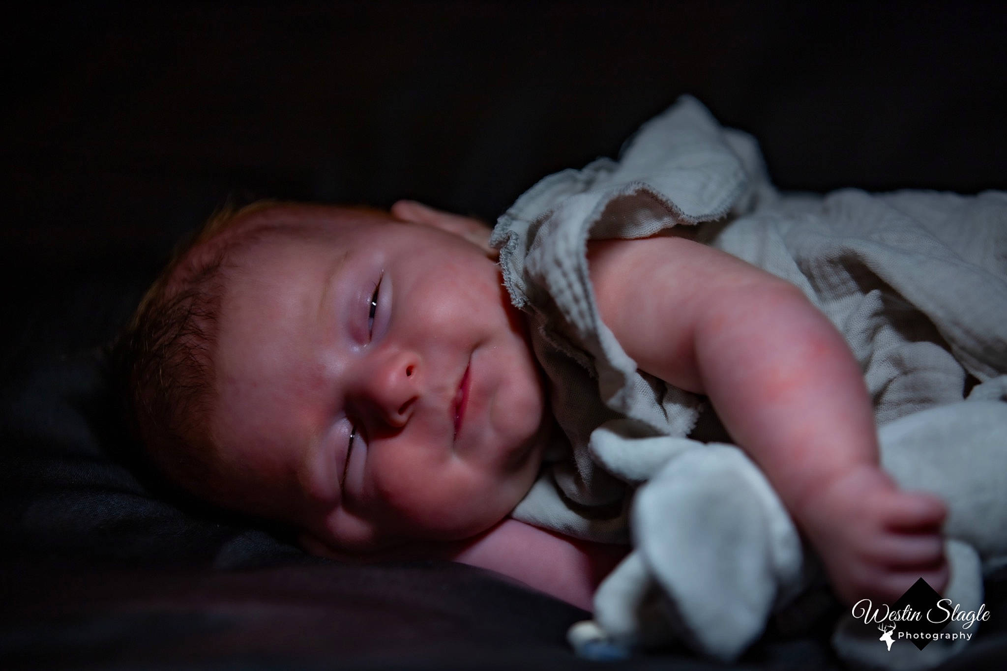 Freyja is registered to the contest to win money with this photo: baby, baby_products, baby_toddler_clothing, bedtime, cheek, child, comfort, darkness, ear, eye, flash_photography, grass, hand, iris, linens, person, portrait_photography, room, sitting, sleep