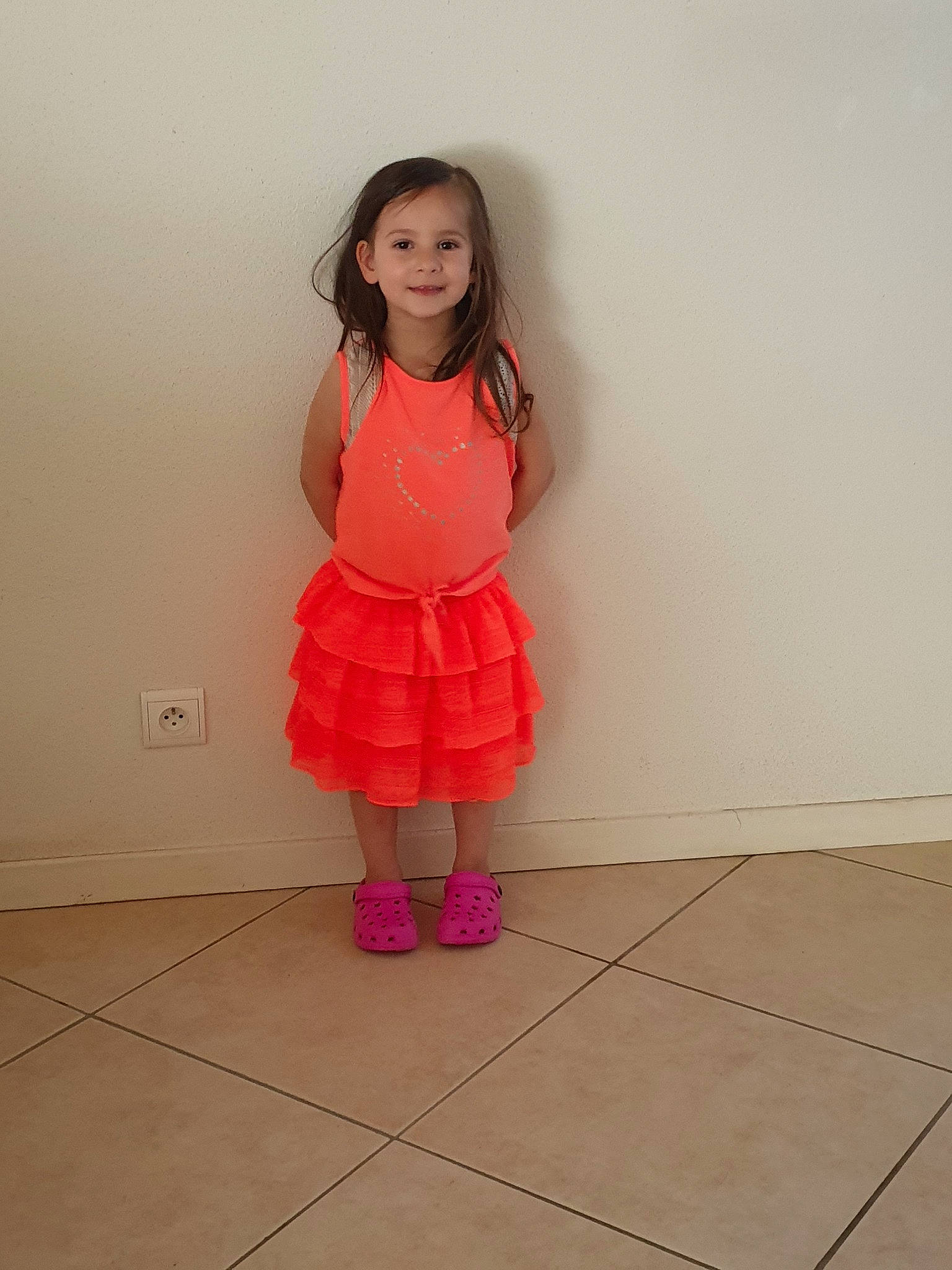 Léana a rejoint le concours — aidez-le/la à gagner de superbes lots ! child, clothing, dress, floor, joint, joy, knee, peach, person, pink, shoulder, skin, standing, toddler