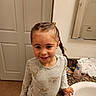 child, girl, smile, braided_hair, pajamas, bathroom, sink, mirror, countertop, soap_dispenser, toiletries, door, tile_floor, happy, standing, cute, indoor, young, person, portrait
