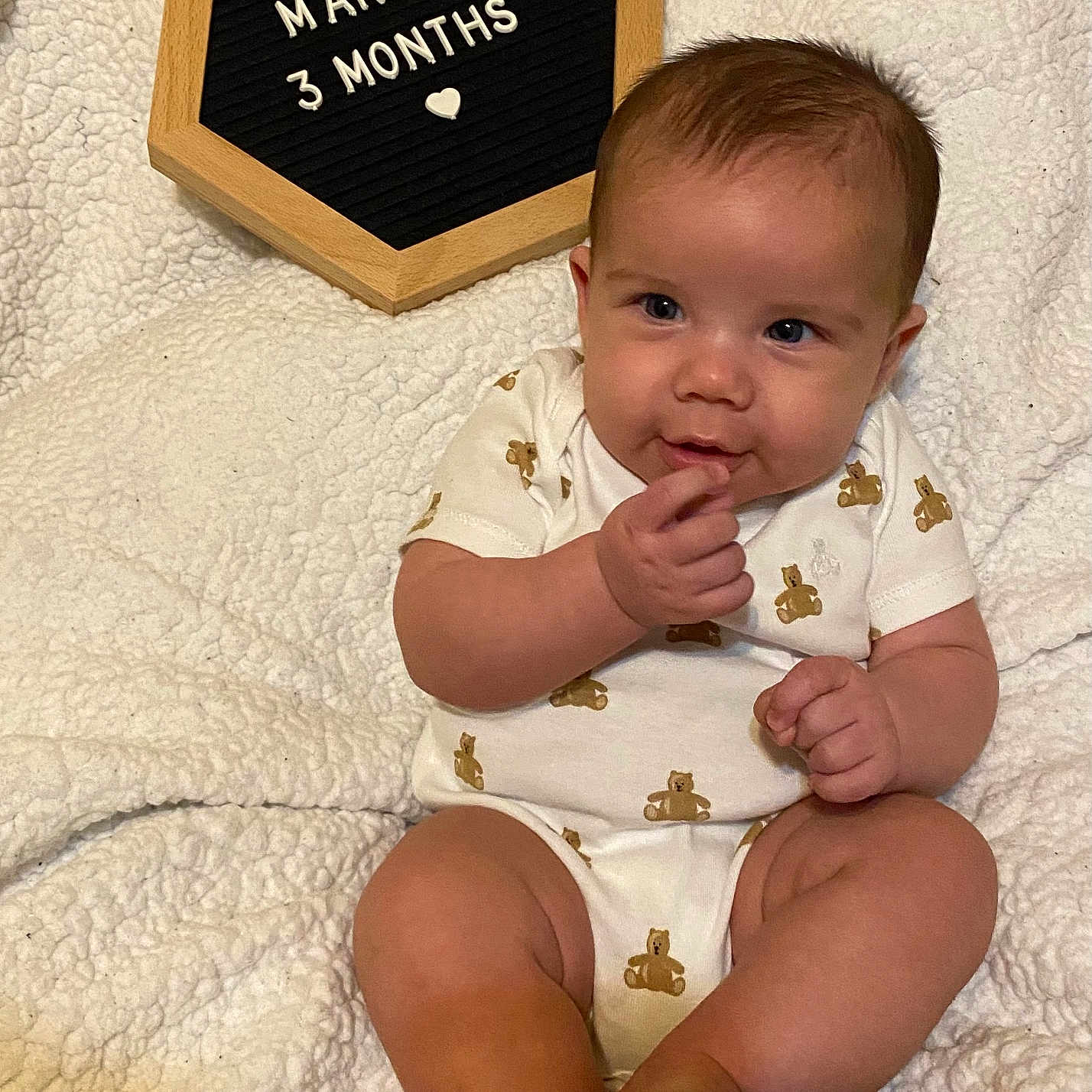 Tyler is registered to the contest to win money with this photo: baby, blonde, bodypart, clothing, diaper, face, finger, hair, hand, happy, head, person, photography, portrait, quilt, sitting, sleeve, smile, symbol, t_shirt
