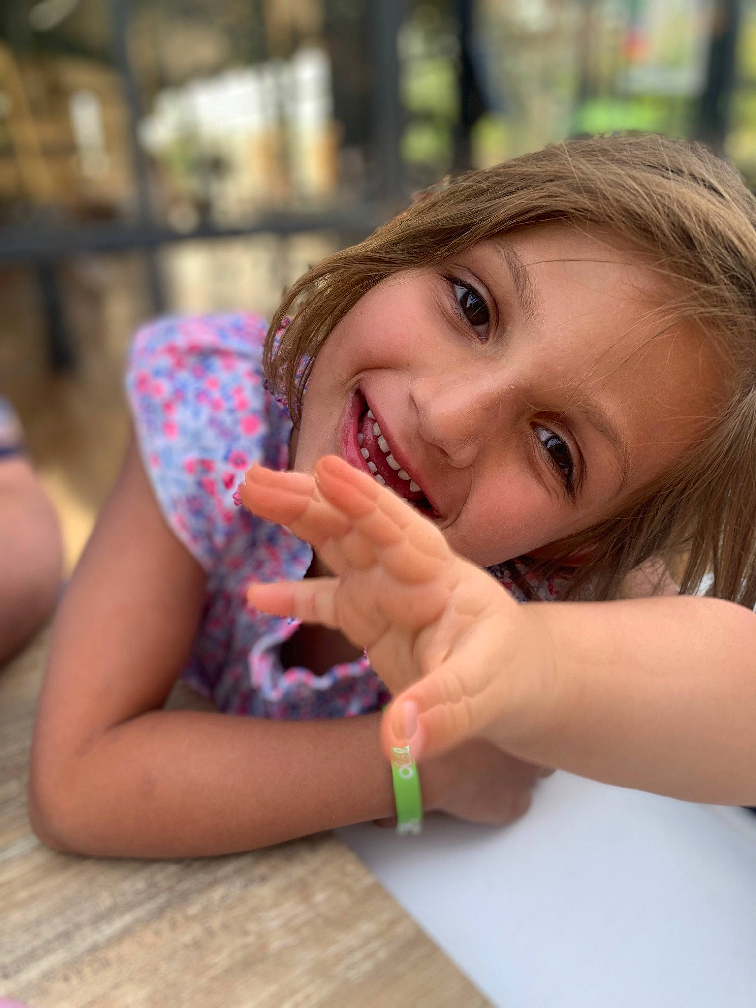 Manon participe au concours pour gagner de l'argent avec cette photo : brown_hair, child, eye, facial_expression, finger, fun, gesture, grass, happy, joy, leisure, lip, people_in_nature, person, recreation, sitting, skin, smile, table, thumb