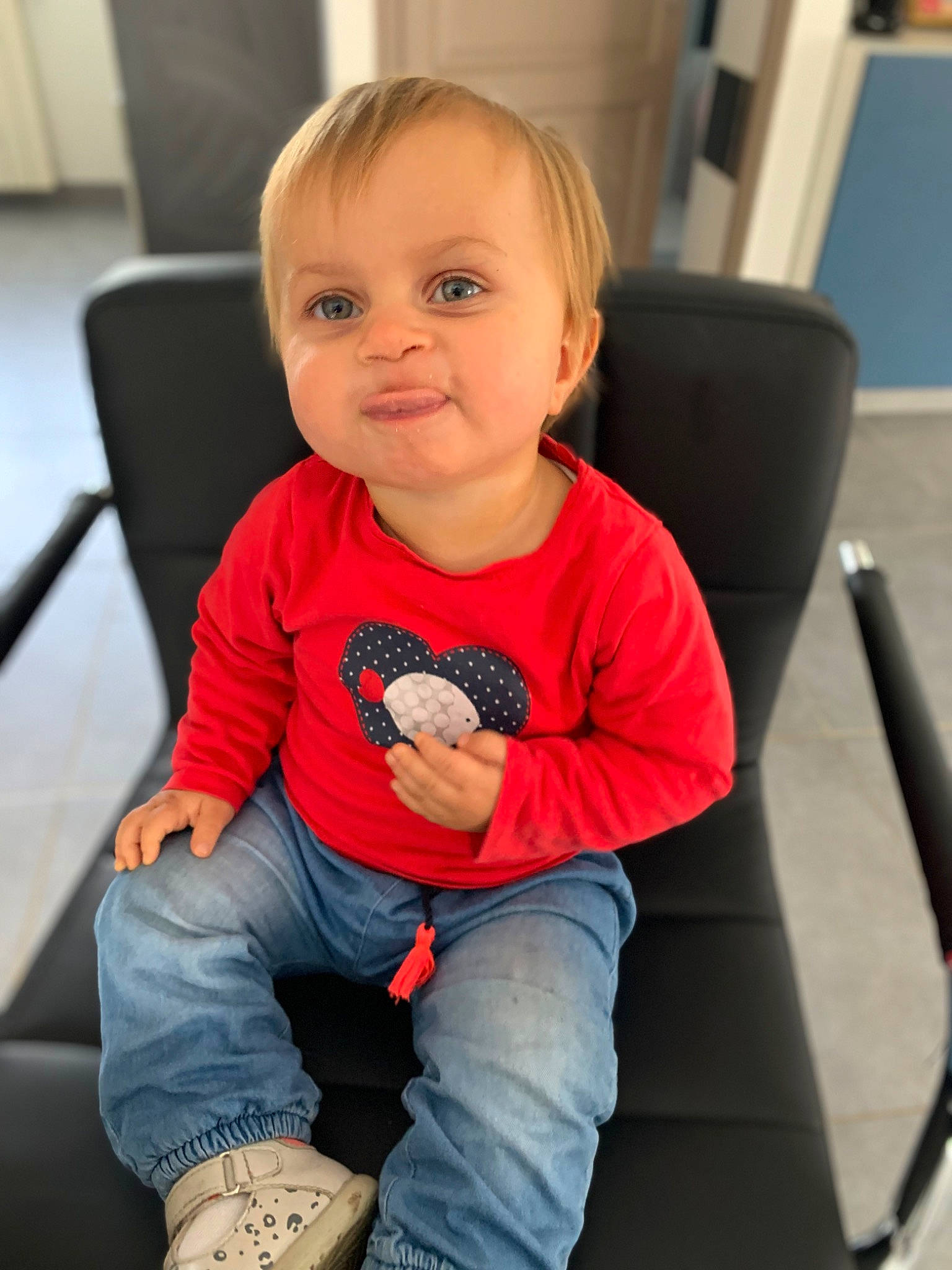 Anaël participe au concours pour gagner de l'argent avec cette photo : baby, baby_toddler_clothing, chair, cheek, child, chin, clothing, comfort, electric_blue, face, hair, head, knee, person, sitting, skin, sleeve, smile, snapshot, t_shirt