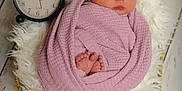 Violet is registered to the contest to win money with this photo: newborn, baby, sleeping, blanket, headband, flower, basket, clock, wooden_floor, soft_texture, cozy, wrapped, infant, peaceful, portrait, floor, fluffy, decor, closeup, indoors