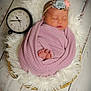 newborn, baby, sleeping, blanket, headband, flower, basket, clock, wooden_floor, soft_texture, cozy, wrapped, infant, peaceful, portrait, floor, fluffy, decor, closeup, indoors