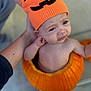 baby, child, pumpkin, hat, orange, costume, hand, face, expression, outdoor, person, skin, cute, holding, headwear, pumpkin_costume, fall, seasonal, portrait, crying