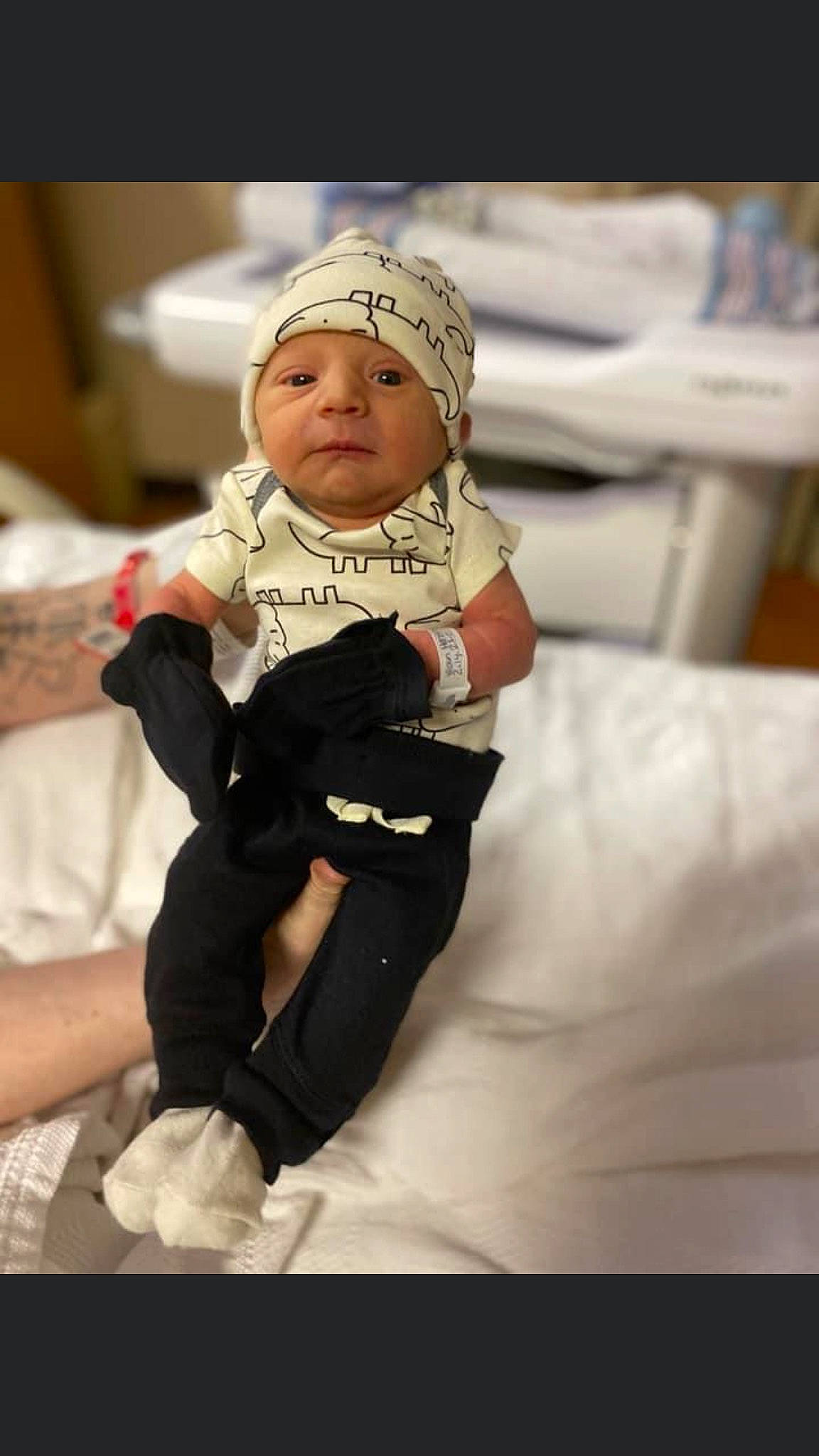 Damon is registered to the contest to win money with this photo: baby, baby_toddler_clothing, cap, child, comfort, event, fashion_accessory, flash_photography, flooring, formal_wear, fun, happy, hat, headwear, knee, linens, person, personal_protective_equipment, sitting, sleeve