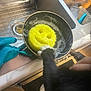 cat, paw, kitchen_sink, pot, soapy_water, yellow_sponge, smiley_face, cleaning_gloves, utensils, black_and_white, domestic, curious, household, countertop, cleaning, foam, hand, water, sink_drain, marble_surface