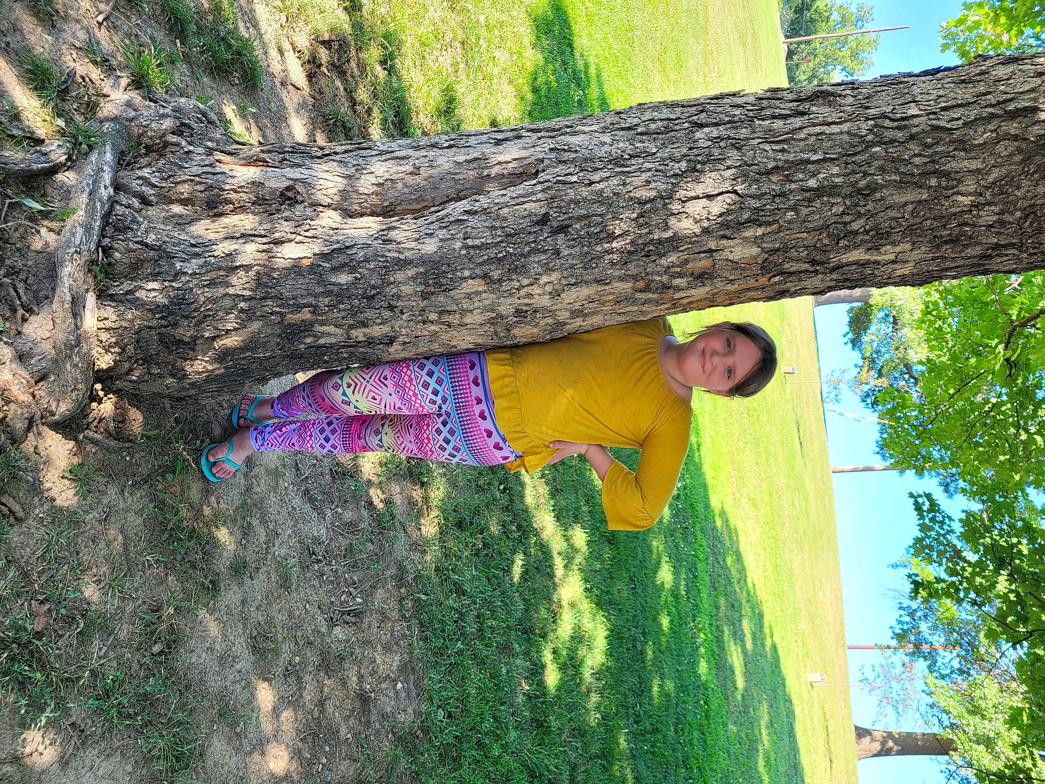 Athena is registered to the contest to win money with this photo: adaptation, biome, botany, branch, grass, green, happy, joy, leaf, leisure, natural_environment, organism, people_in_nature, person, plant, sky, smile, tree, trunk, wood