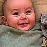 Noah participe au concours pour gagner de l'argent avec cette photo : baby, smiling, face, eyes, blanket, green_clothing, closeup, infant, cute, happy, skin, head, person, child, cozy, texture, soft, indoors, portrait, lying_down