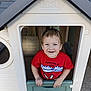 child, boy, playhouse, toy_house, smiling, red_shirt, spiderman, blue_eyes, short_hair, outdoor, play, plastic, door, hand, happy, casual_clothing, young, cute, fun, portrait