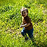 child, toddler, grass, outdoor, smiling, running, sunlight, field, greenery, happy, casual_clothing, nature, daylight, person, playful, young_child, grass_field, joyful, bright, active