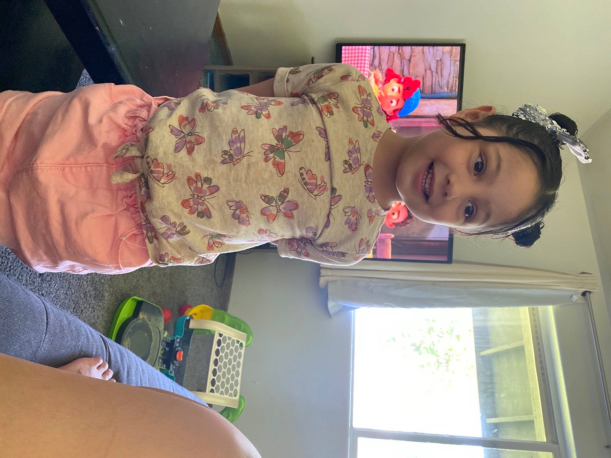 Epiphany is registered to the contest to win money with this photo: arm, child, comfort, fun, headgear, house, human_leg, joy, leg, magenta, pattern, person, picture_frame, pink, room, skin, smile, textile, thigh, toddler