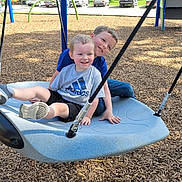 Rylan joined the competition — help win amazing prizes! children, playground, swing, smiling, happy, outdoor, summer, fun, park, woodchips, blue_swing, casual_clothing, shorts, tshirt, trees, cars, daylight, friends, play, joy