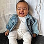 Alaiyah joined the competition — help win amazing prizes! baby, smiling, denim_jacket, white_outfit, ribbed_clothing, infant, happy, sitting, couch, blanket, indoor, portrait, cute, child, face, head, person, cozy, clothing, background