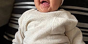 Alaiyah is registered to the contest to win money with this photo: baby, child, smiling, headband, bow, knitwear, sitting, cushion, striped, clothing, happy, infant, portrait, indoor, cute, fashion, cozy, person, face, expression